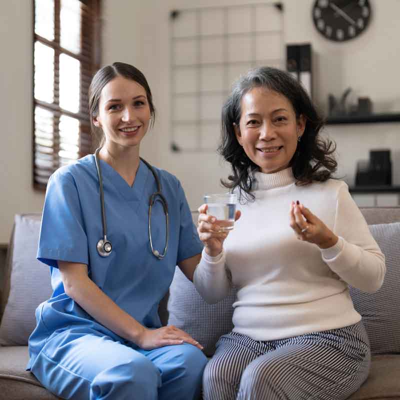 In-home nurse with patient before taking her pills.
